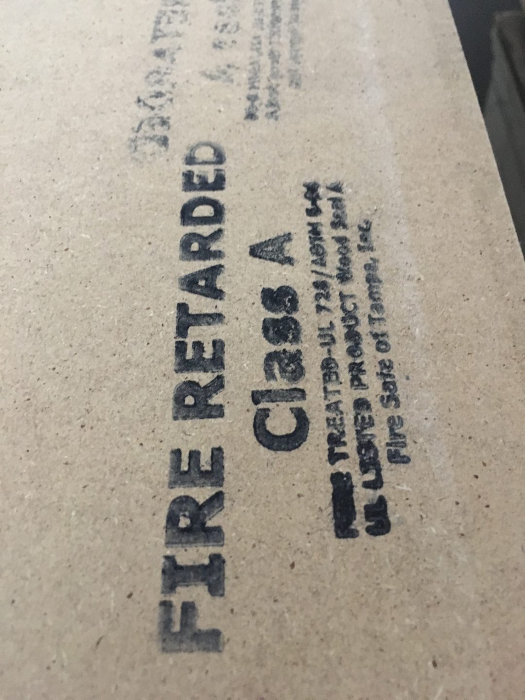 Close-up of Fire Retarded Class A stamp on plywood panel edge — UL listed FRT certification