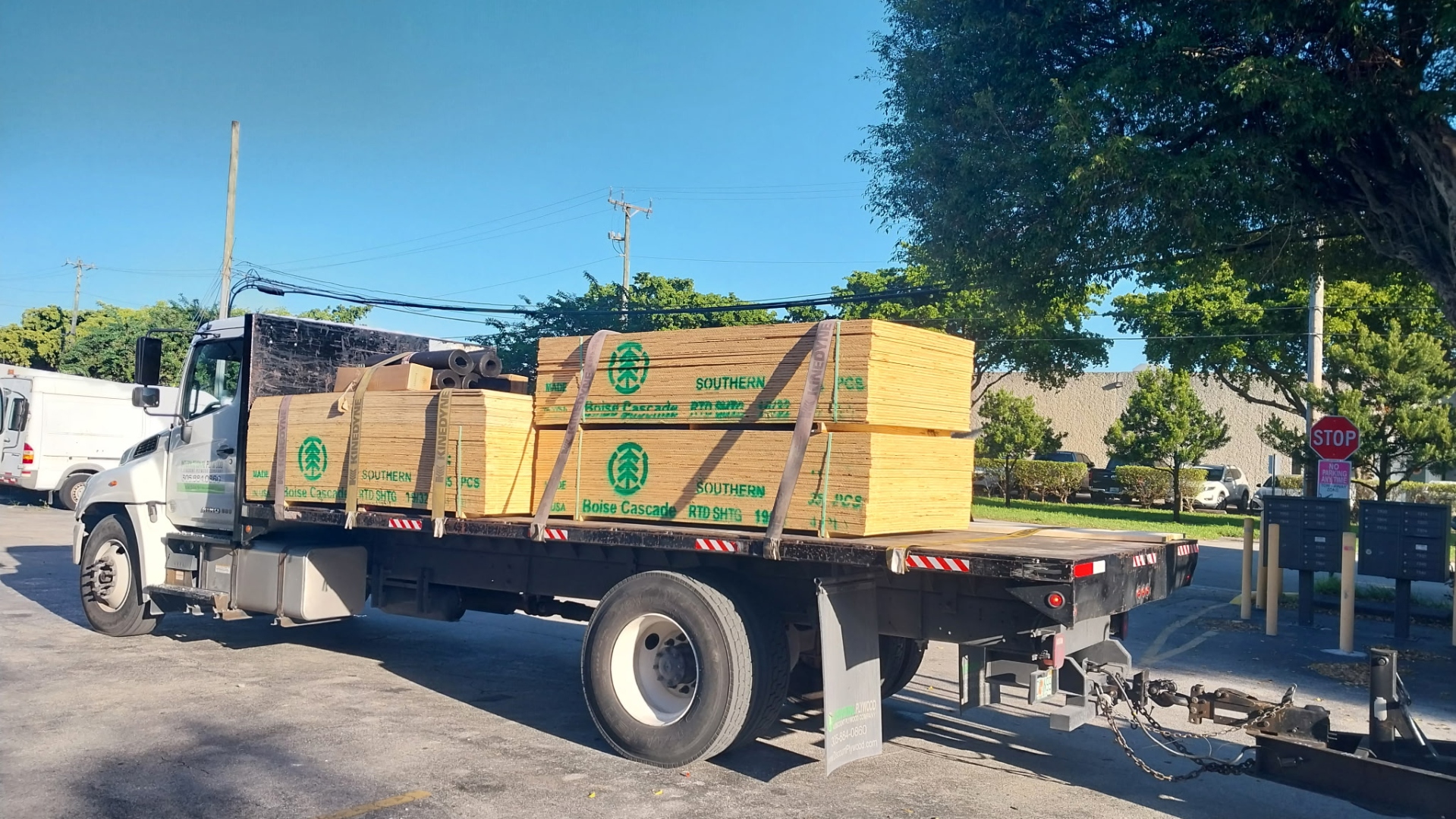 Flatbed truck loaded with Boise Cascade Southern CDX plywood panels leaving International Plywood yard for Miami job site delivery